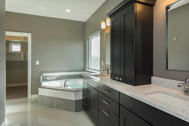 Inspiration for a large contemporary master beige floor corner bathtub remodel in Cedar Rapids with shaker cabinets, dark wood cabinets, gray walls, an undermount sink and terrazzo countertops