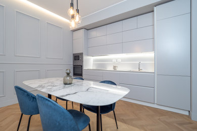 Esempio di una sala da pranzo minimalista con parquet chiaro, pavimento beige, soffitto ribassato e boiserie