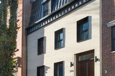 Inspiration for a contemporary beige brick townhouse exterior remodel in New York with a metal roof