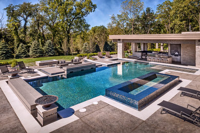 Inspiration for a large backyard custom-shaped pool in Chicago with a hot tub and stamped concrete.