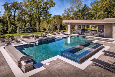 Hot tub - large backyard stamped concrete and custom-shaped hot tub idea in Chicago