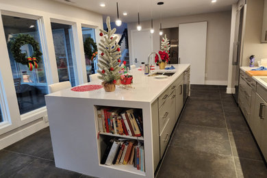 Example of a large minimalist single-wall ceramic tile and gray floor enclosed kitchen design in Other with a single-bowl sink, flat-panel cabinets, gray cabinets, granite countertops, stainless steel appliances and white countertops