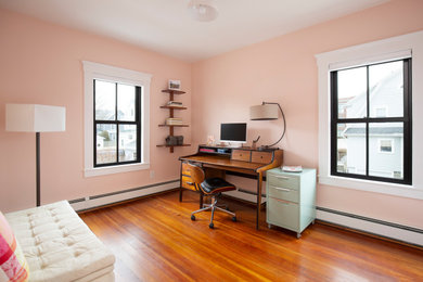 Example of a mid-sized classic freestanding desk medium tone wood floor study room design in Boston with pink walls