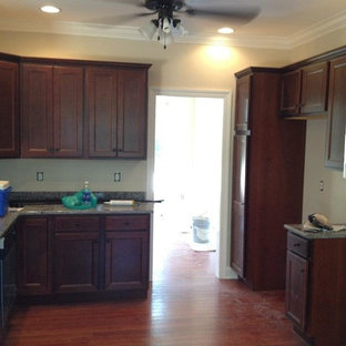 Large kitchen pantry ideas - Large u-shaped medium tone wood floor kitchen pantry photo in Huntington with a drop-in sink, recessed-panel cabinets, dark wood cabinets, granite countertops, gray backsplash, stainless steel appliances and no island