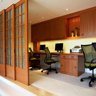 Asiatisk inredning av ett mellanstort hemmabibliotek, med vita väggar, heltäckningsmatta och ett inbyggt skrivbord