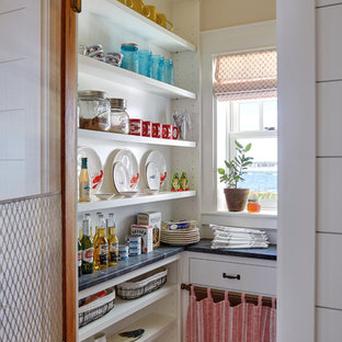 Beach style l-shaped kitchen pantry in Portland Maine with open cabinets, white cabinets and black benchtop.