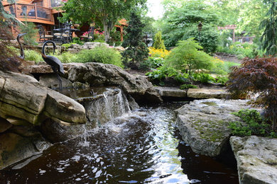 Design ideas for a large traditional backyard stone water fountain landscape in St Louis.