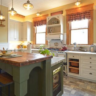 Photo of a small traditional l-shaped separate kitchen in San Luis Obispo with a farmhouse sink, raised-panel cabinets, green cabinets, quartzite benchtops, white splashback, subway tile splashback, panelled appliances, brick floors, with island, grey floor and white benchtop.