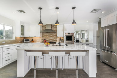 Photo of a transitional u-shaped kitchen in Los Angeles with a single-bowl sink, shaker cabinets, white cabinets, brown splashback, stainless steel appliances, with island, grey floor and grey benchtop.