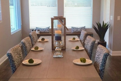 Example of a mid-sized trendy medium tone wood floor and brown floor enclosed dining room design in Tampa with beige walls and no fireplace