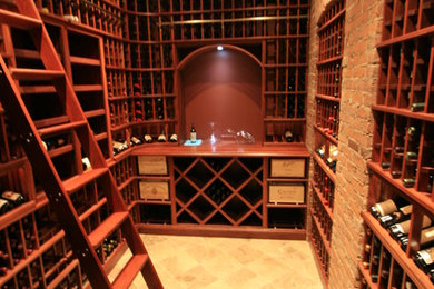 This is an example of a mid-sized traditional wine cellar in New York with travertine floors, storage racks and beige floor.