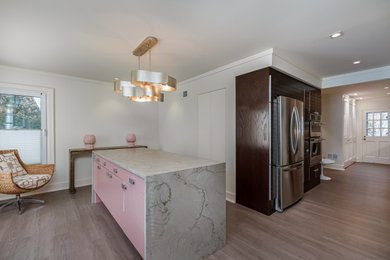 Mid-sized trendy l-shaped vinyl floor and gray floor eat-in kitchen photo in Milwaukee with an undermount sink, brown cabinets, quartz countertops, white backsplash, subway tile backsplash, stainless steel appliances, an island, gray countertops and flat-panel cabinets