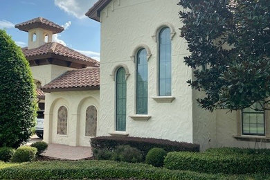 Modelo de fachada de casa beige y marrón de estilo americano de tamaño medio de dos plantas con revestimiento de estuco, tejado a cuatro aguas y tejado de teja de barro