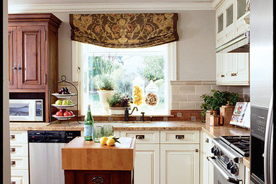 Inspiration for a small timeless l-shaped terra-cotta tile eat-in kitchen remodel in San Diego with an undermount sink, raised-panel cabinets, white cabinets, wood countertops, green backsplash, subway tile backsplash, stainless steel appliances and an island