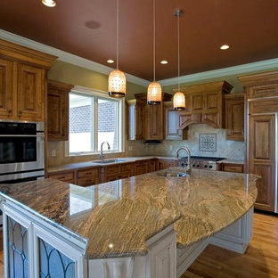 Large traditional kitchen pantry remodeling - Kitchen pantry - large traditional l-shaped light wood floor kitchen pantry idea in Cincinnati with a drop-in sink, raised-panel cabinets, medium tone wood cabinets, granite countertops, beige backsplash, ceramic backsplash, stainless steel appliances and an island