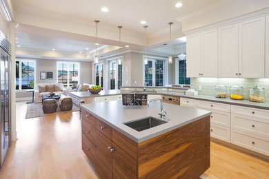Eat-in kitchen - transitional u-shaped light wood floor eat-in kitchen idea in San Francisco with an undermount sink, shaker cabinets, white cabinets, quartz countertops, subway tile backsplash, stainless steel appliances and an island