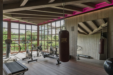 Inspiration for a large contemporary multipurpose gym in Other with grey walls, medium hardwood floors and grey floor.