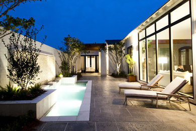 Inspiration for a large contemporary courtyard stone patio fountain remodel in New Orleans with no cover