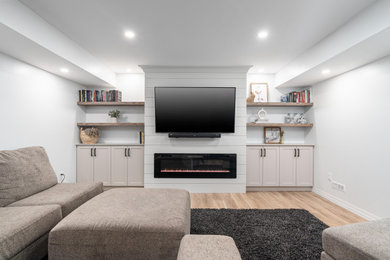 Example of a large cottage chic vinyl floor and beige floor basement design in Other with a shiplap fireplace