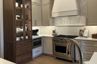 Kitchen - mid-sized traditional light wood floor kitchen idea in Oklahoma City with a farmhouse sink, flat-panel cabinets, beige cabinets, quartz countertops, white backsplash, a peninsula and white countertops