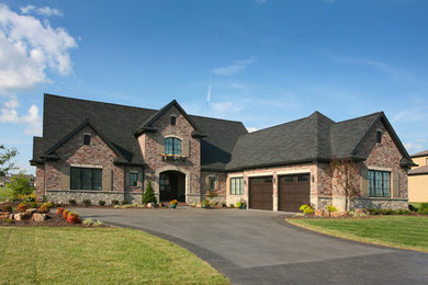 Large traditional red two-story brick gable roof idea in Other