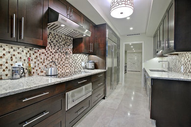 Mid-sized transitional galley open plan kitchen in Miami with an undermount sink, shaker cabinets, dark wood cabinets, brown splashback, stainless steel appliances, no island, granite benchtops, glass sheet splashback and marble floors.