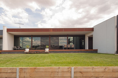 This is an example of an expansive contemporary garden in Melbourne.