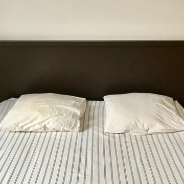 Mobilier sur mesure autour d'un poêle à bois et tête de lit