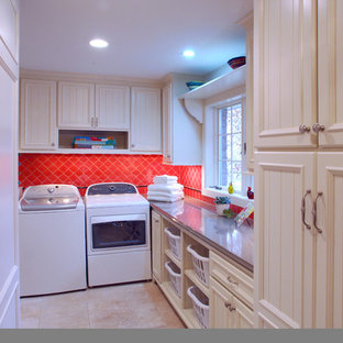 Bohemian l-shaped separated utility room in Minneapolis with white cabinets, red walls, travertine flooring, a side by side washer and dryer and recessed-panel cabinets.