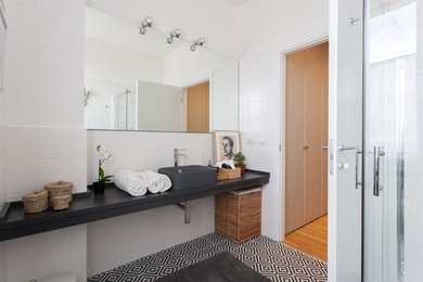 Immagine di una stanza da bagno tradizionale con nessun'anta, ante nere, piastrelle bianche, pareti bianche, pavimento nero, doccia ad angolo, top nero e lavabo a bacinella