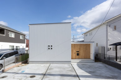 Zweistöckiges Einfamilienhaus mit weißer Fassadenfarbe, Pultdach und Blechdach