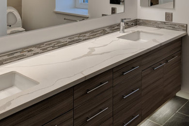 Example of a large minimalist master beige tile and porcelain tile porcelain tile, black floor and double-sink bathroom design in Seattle with flat-panel cabinets, brown cabinets, gray walls, quartz countertops, white countertops and a floating vanity