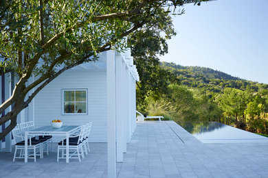 Large cottage backyard stone patio photo in San Francisco with a roof extension