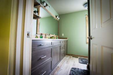 Walk-in shower - mid-sized rustic green tile and glass tile ceramic tile walk-in shower idea in New York with an undermount sink, recessed-panel cabinets, brown cabinets, granite countertops, a one-piece toilet and green walls