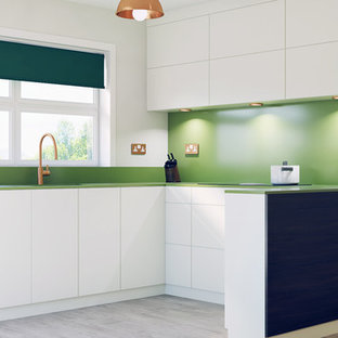 Photo of a mid-sized contemporary u-shaped eat-in kitchen in Cambridgeshire with flat-panel cabinets, white cabinets, solid surface benchtops, green splashback, no island and green benchtop.