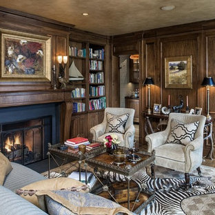 This is an example of a large traditional study room in New York with brown walls, dark hardwood floors, a standard fireplace, a concrete fireplace surround and brown floor.