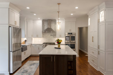 Example of a large transitional eat-in kitchen design in Chicago with shaker cabinets, white cabinets, gray backsplash, stainless steel appliances, an island and white countertops