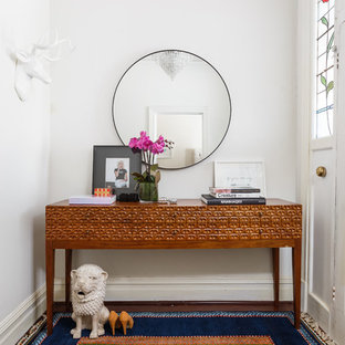 Exempel på en eklektisk hall, med vita väggar, en vit dörr och flerfärgat golv