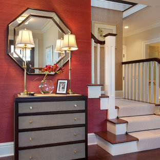 Bild på en mellanstor eklektisk foajé, med röda väggar, mörkt trägolv, en enkeldörr, mörk trädörr och brunt golv