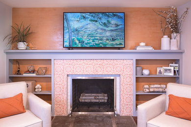 На фото: гостиная комната среднего размера в современном стиле с оранжевыми стенами, стандартным камином, фасадом камина из плитки, отдельно стоящим телевизором и обоями на стенах с