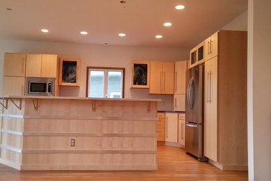 This is an example of a modern l-shaped kitchen in Other with flat-panel cabinets, quartz benchtops and with island.
