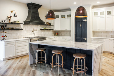 Design ideas for a large country u-shaped kitchen pantry in St Louis with a farmhouse sink, glass-front cabinets, white cabinets, quartz benchtops, white splashback, ceramic splashback, stainless steel appliances, light hardwood floors, with island, brown floor and yellow benchtop.