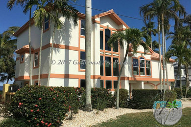 Inspiration for a large coastal white three-story house exterior remodel in Other with a tile roof