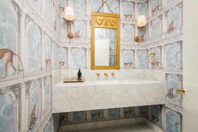 This is an example of a traditional powder room in Sydney with white cabinets and marble benchtops.