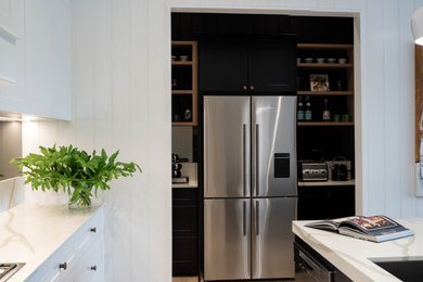 Photo of a large contemporary galley kitchen pantry in Sydney with an undermount sink, shaker cabinets, white cabinets, quartz benchtops, grey splashback, mirror splashback and with island.