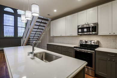 Small trendy galley medium tone wood floor and brown floor eat-in kitchen photo in Baltimore with an undermount sink, shaker cabinets, white cabinets, quartz countertops, white backsplash, subway tile backsplash, stainless steel appliances and an island