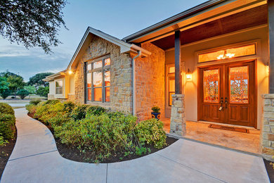 This is an example of a large traditional one-storey beige house exterior in Austin with mixed siding.