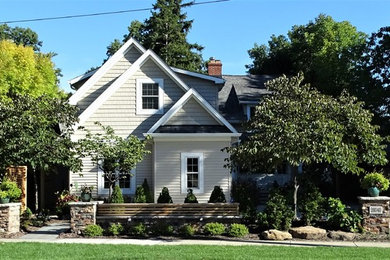 Photo of a mid-sized traditional partial sun front yard concrete paver retaining wall landscape in Cleveland.