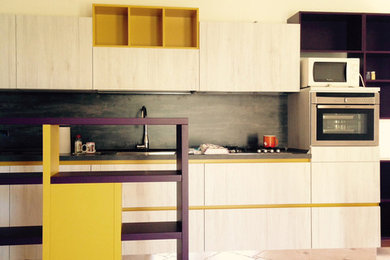 Photo of a modern l-shaped open plan kitchen in Other with light wood cabinets and brown worktops.