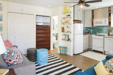 Inspiration for a small coastal vinyl floor family room remodel in San Diego with yellow walls and a wall-mounted tv